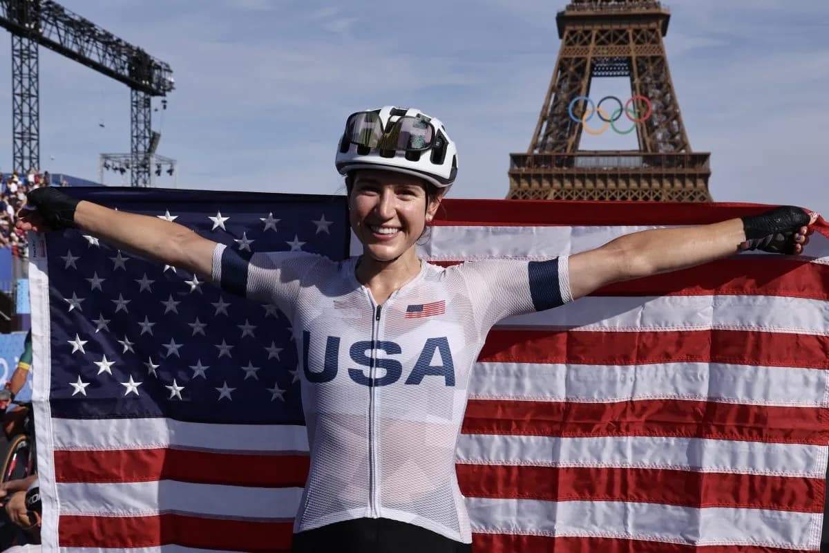 Kristen Faulkner with Olympic flag at the Eiffel Tower after winning road race gold in Paris
